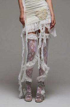 Person in a white ruffled dress and lace stockings with exposed skin