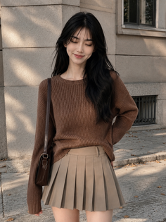 Woman with long black hair wearing a brown sweater and pleated skirt outdoors