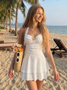Woman in a white dress with a straw bag on a sunny beach with palm trees