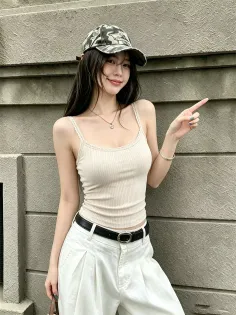 Woman with long hair wearing a camo cap and tank top, pointing to the side