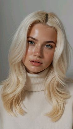 Woman with blonde hair and freckles wearing a cream turtleneck sweater