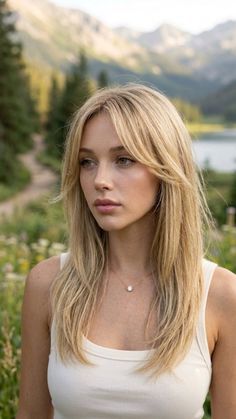 Blonde woman in a tank top with a necklace outdoors