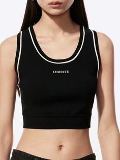 Woman in a black crop top with white trim, showing her midriff