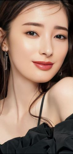 Woman with long hair and earrings wearing a black dress