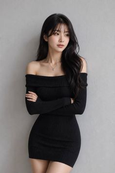Woman in a black off-shoulder dress with long dark hair and a heart necklace