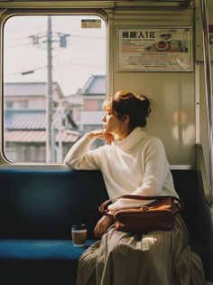 Woman in a white turtleneck sweater looking out a train window