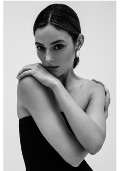 Woman with freckles and bare shoulders in a black and white studio portrait