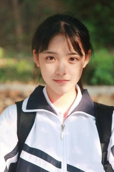 Young woman in a school uniform with a backpack outdoors
