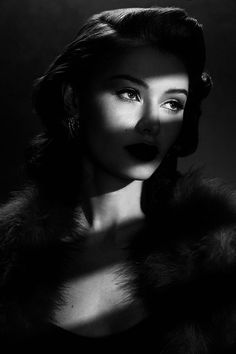 Woman in a fur coat with dramatic lighting and dark lipstick