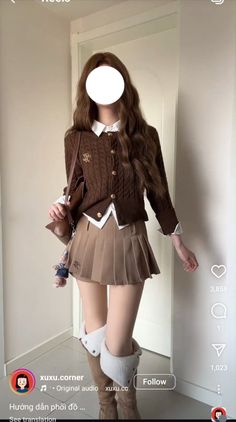 Person in a brown cardigan and pleated skirt with knee-high boots indoors