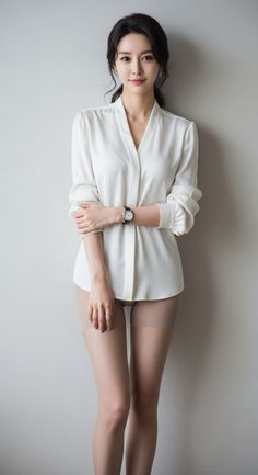 Woman in a white blouse and sheer tights posing indoors