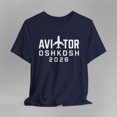 Navy blue t-shirt with 'AVIATOR OSHKOSH 2026' text and an airplane graphic