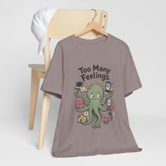 T-shirt with a cartoon octopus holding various items and text 'Too Many Feelings'