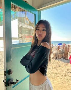 Woman with long hair in an off-shoulder top and sweatpants at the beach