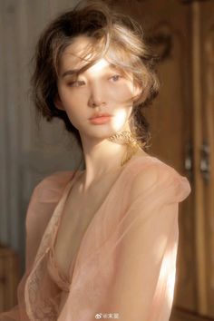 Woman in a pink dress with a butterfly necklace in soft golden hour light