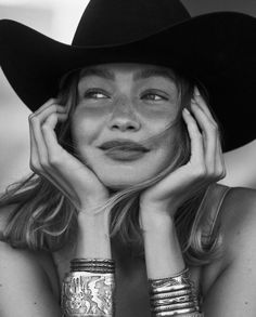 Woman in a cowboy hat with freckles and silver bracelets in black and white