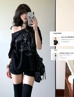 Woman in a black t-shirt and shorts taking a mirror selfie