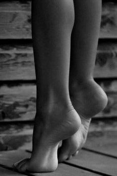Bare feet and legs on a wooden floor in black and white