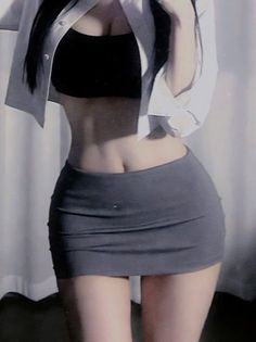 Woman in a black crop top and grey mini skirt with an open white shirt