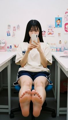 Woman with long dark hair taking a mirror selfie while sitting indoors