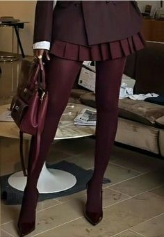 Person in a burgundy mini skirt, tights, and high heels holding a matching handbag