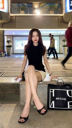 Woman with long hair sitting outdoors at night with motion blur in the background