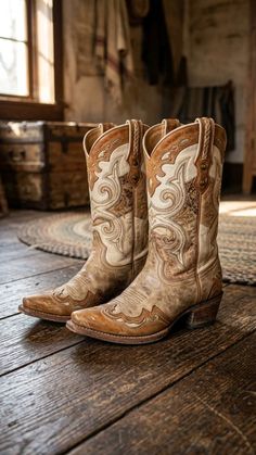 Pair of ornate cowboy boots on a rustic wooden floor indoors