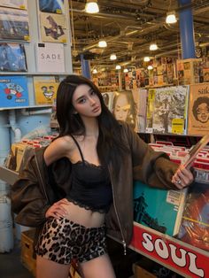 Woman in a record store wearing a black camisole and leopard print shorts