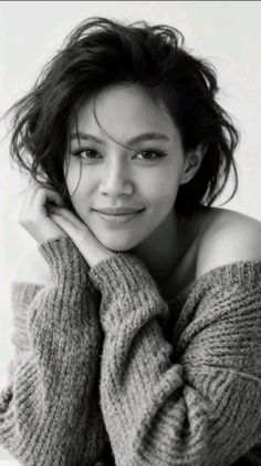 Woman with short black hair wearing an off-shoulder sweater, in black and white