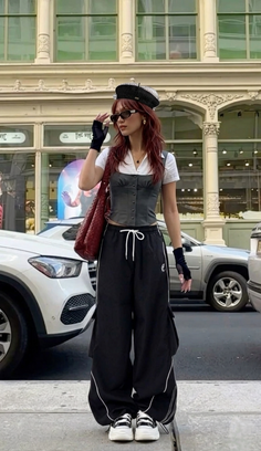 Woman in a beret and baggy pants on a city street during the day