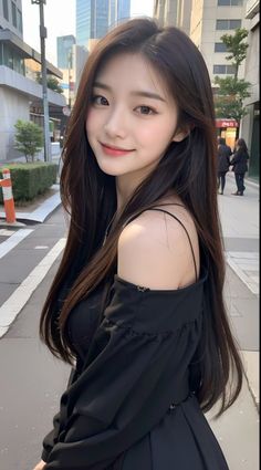 Woman with long dark hair in a black off-shoulder dress on a city street
