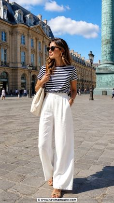 Woman in a striped t-shirt and white wide-leg pants on a cobblestone street