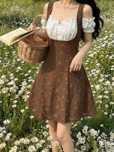 Woman in a brown dress and white blouse holding a picnic basket in a daisy field
