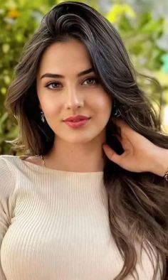 Woman with long brown hair wearing a ribbed top and earrings outdoors