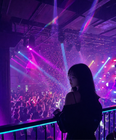 Woman in a nightclub with neon lights and confetti falling over a crowd