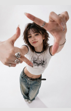 Woman with shaggy hair and baggy jeans making a frame with her hands