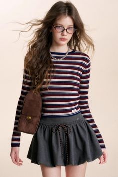Young woman with long hair, glasses, and a striped shirt in a studio