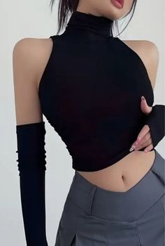 Woman in a black crop top and grey skirt with exposed midriff