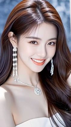 Smiling woman with long hair wearing a white dress and jewelry