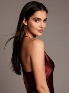 Woman in a red dress looking over her shoulder with hair blowing
