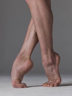 Close up of a dancer's legs and feet in a ballet pose