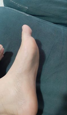 A close up of a bare foot on a dark green surface