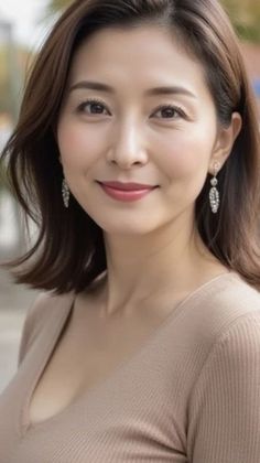 Woman with short brown hair and earrings wearing a v-neck top