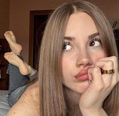 Woman with long hair and freckles posing indoors with exposed skin