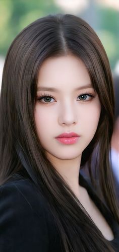 Woman with long dark hair and pink lips looking directly at the viewer