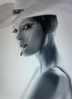 Woman in a cowboy hat with a cigarette in her mouth, black and white portrait