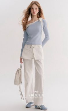 Woman with long hair wearing an off-shoulder top and white pants in a studio