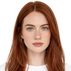 Woman with red hair, freckles, and blue eyes looking directly at the camera
