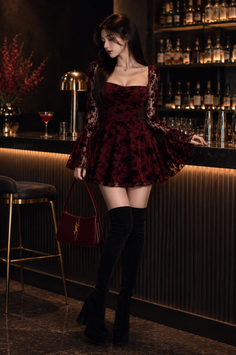 Woman in a red dress and thigh-high boots standing at a bar counter