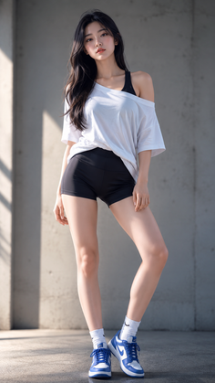 Woman with long black hair wearing a white t-shirt and black shorts outdoors